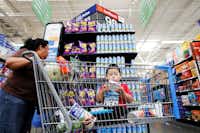 Bernarda Ortiz, 54, with her grandson Julian Ortiz, 3, shops for Takis corn chips at the Wal-Mart on Webb Chapel Road in northwest Dallas. Wal-Mart has changed its stores over the years by adding more Latino brands and Spanish signage to accommodate their Spanish-speaking customers. (Ben Torres/Special Contributor)