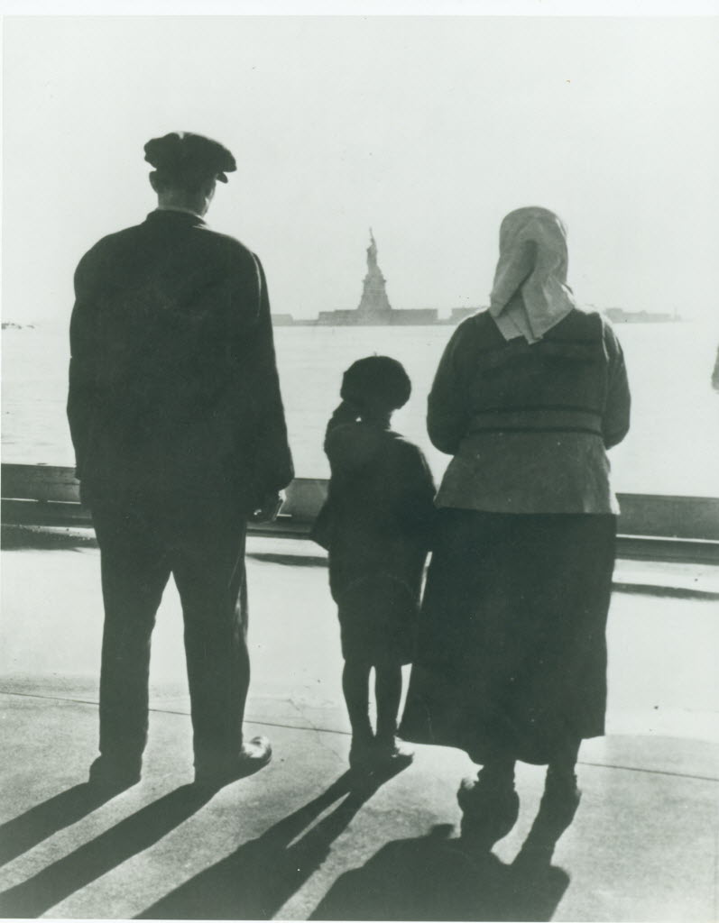A newly arrived immigrant family on Ellis Island gazes across the bay at the Statue of Liberty, in an undated handout photo. (National Park Service, Statue of Liberty NM via The New York Times)&nbsp;NYT