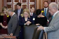 State Sen. Sylvia Garcia, D-Houston, and Sen. Donna Campbell, R-New Braunfels, joined hands during the opening prayer in the Senate Chamber at the Texas Capitol on Tuesday, Feb. 7, 2017, in Austin. (Eric Gay/The Associated Press)
