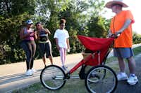 Milt Strong stops while pedestrians take pictures of his chicken Summer along the Katy Trail.(Rose Baca/Staff Photographer)