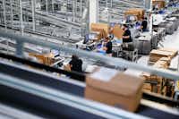 In this May 17, 2017, photo, workers operate packaging stations that feed into an expansive system of conveyor belts connecting separate factory areas at a Festo distribution center in Mason, Ohio. "None of these technologies work without the people," said Carolin McCaffrey, head of Learning Center Midwest for Festo Didactics, which last year launched two-year apprenticeship programs in mechatronics. (John Minchillo/AP)