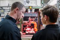  A.J. Scherman, 37, left, works with fellow apprentice Ryan Buzzy, 18, right, on a robotics control computer at a chainsaw assembly line at a Stihl Inc. production plant in Virginia Beach, Va. (John Minchillo/AP)