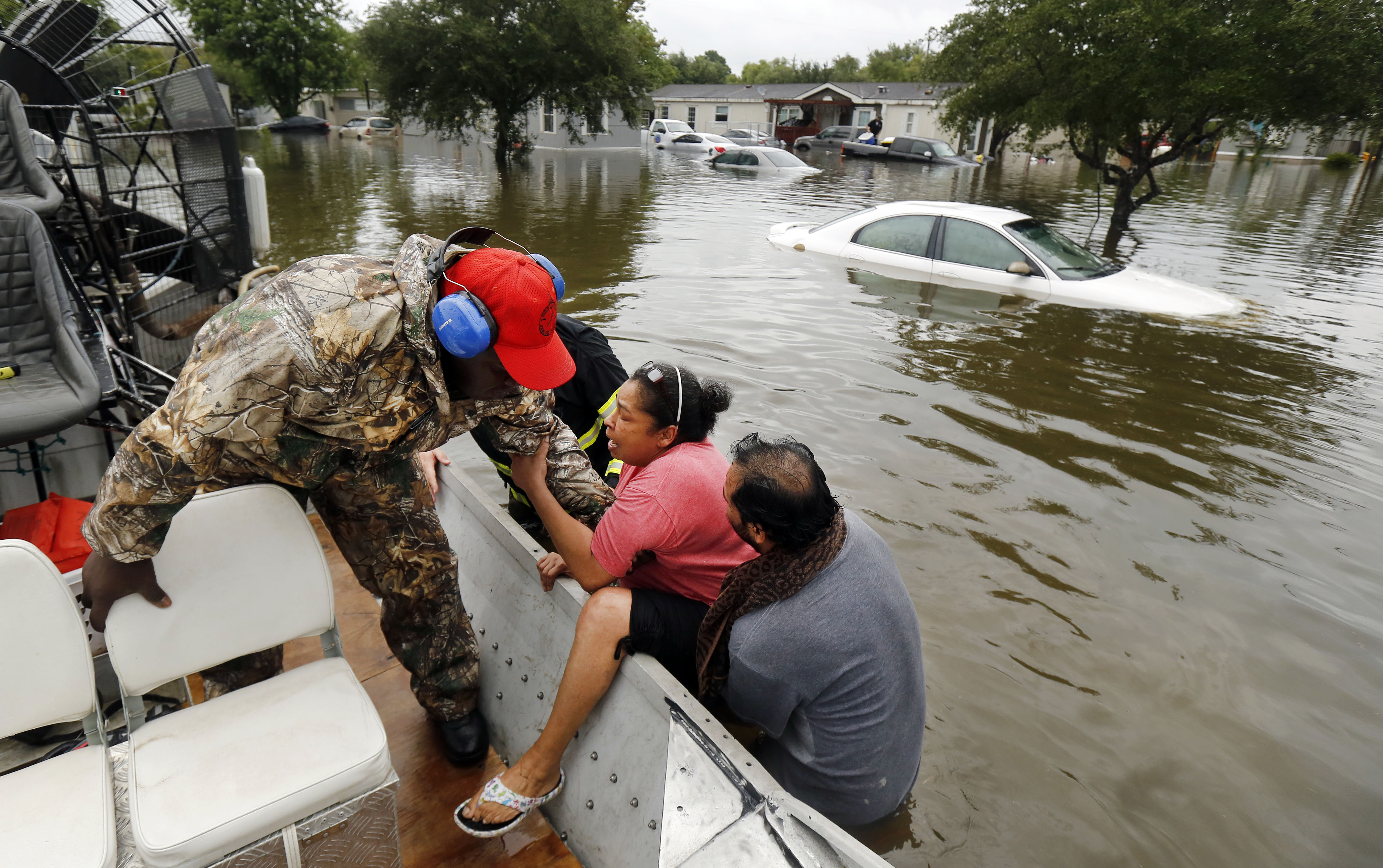 Gulf Coast Rescue Squad air boat driver Felton Jones pulls LaJuana Cinseros into the boat with the help of her husband, Freddie Cisneros, as they were rescued from their flooded home in Pearland Acres Mobile Home Community in Pearland.&nbsp;(Tom Fox/Staff Photographer)