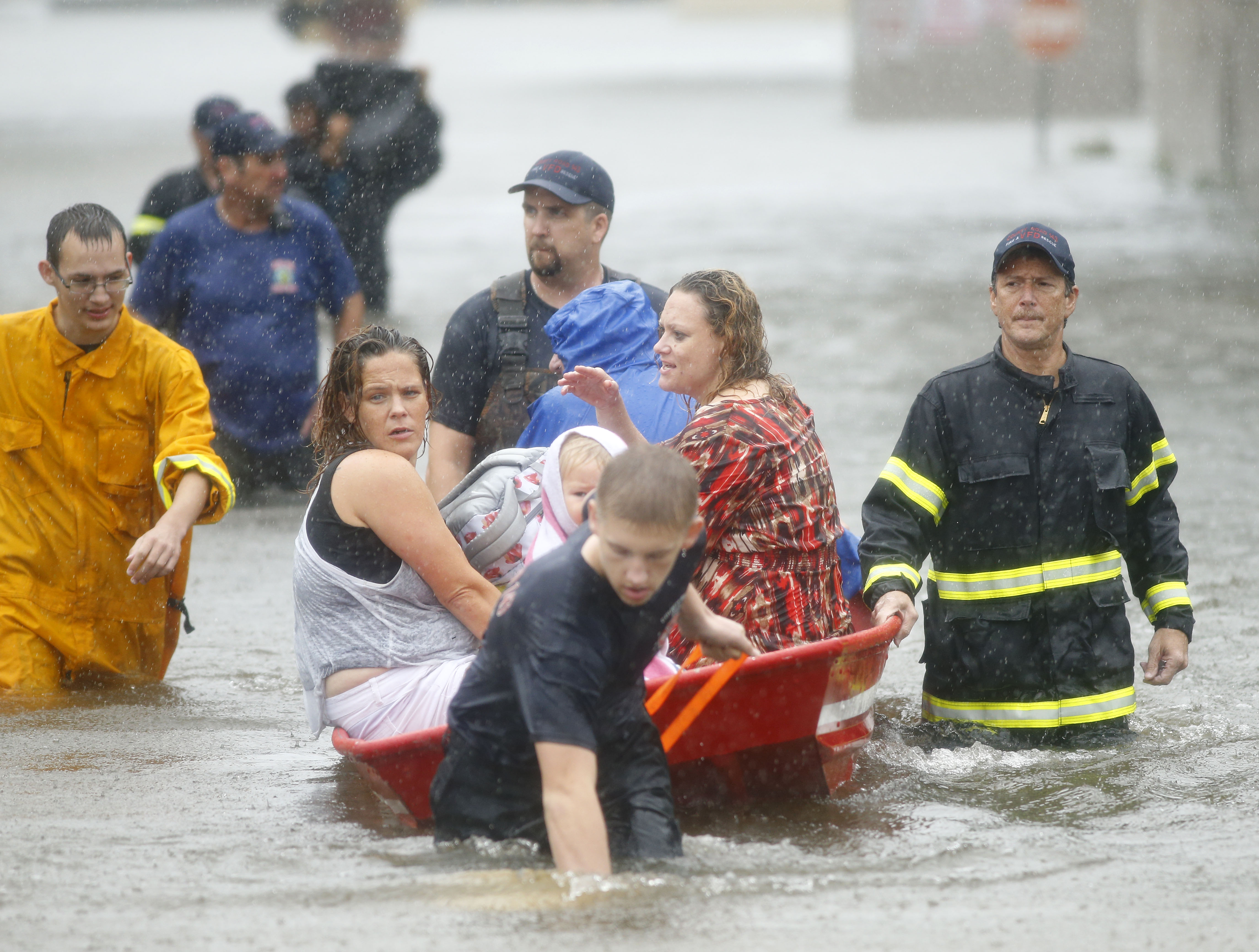 County Road 143 Volunteer Fire Department members (from left) Colby Maynor (in yellow), Derek Lacy, Marcelo DeLeon and Kadyn Truitt (in front) rescue folks stranded in their flooded homes Sunday at Pearland Acres Mobile Home Community.&nbsp;(Tom Fox/Staff Photographer)
