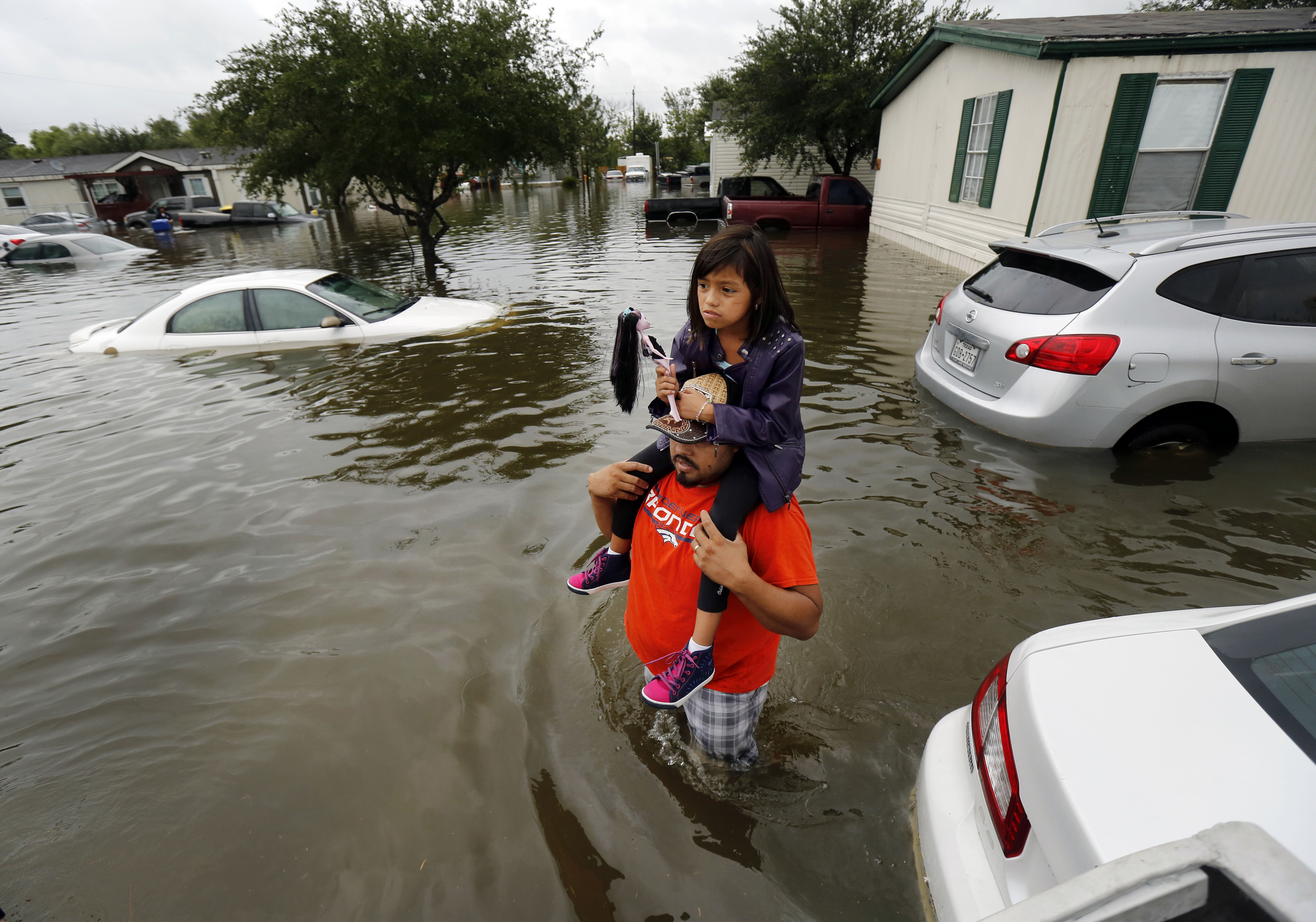 Herman Benitez carries his 9-year-old daughter, Pearl, through flood waters to a rescue boat Sunday after they were flooded out of their home in Pearland Acres Mobile Home Community&nbsp;(Tom Fox/Staff Photographer)