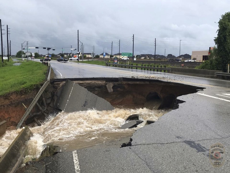In this photo provided by the Rosenberg Police Department water rushes from a large sinkhole on Highway FM 762 in Rosenberg, Texas, near Houston, Sunday, Aug. 27, 2017. Police say the sinkhole has opened on the Texas highway as Tropical Storm Harvey dumps more rain on the region. (Rosenberg Police Department via AP)(AP)