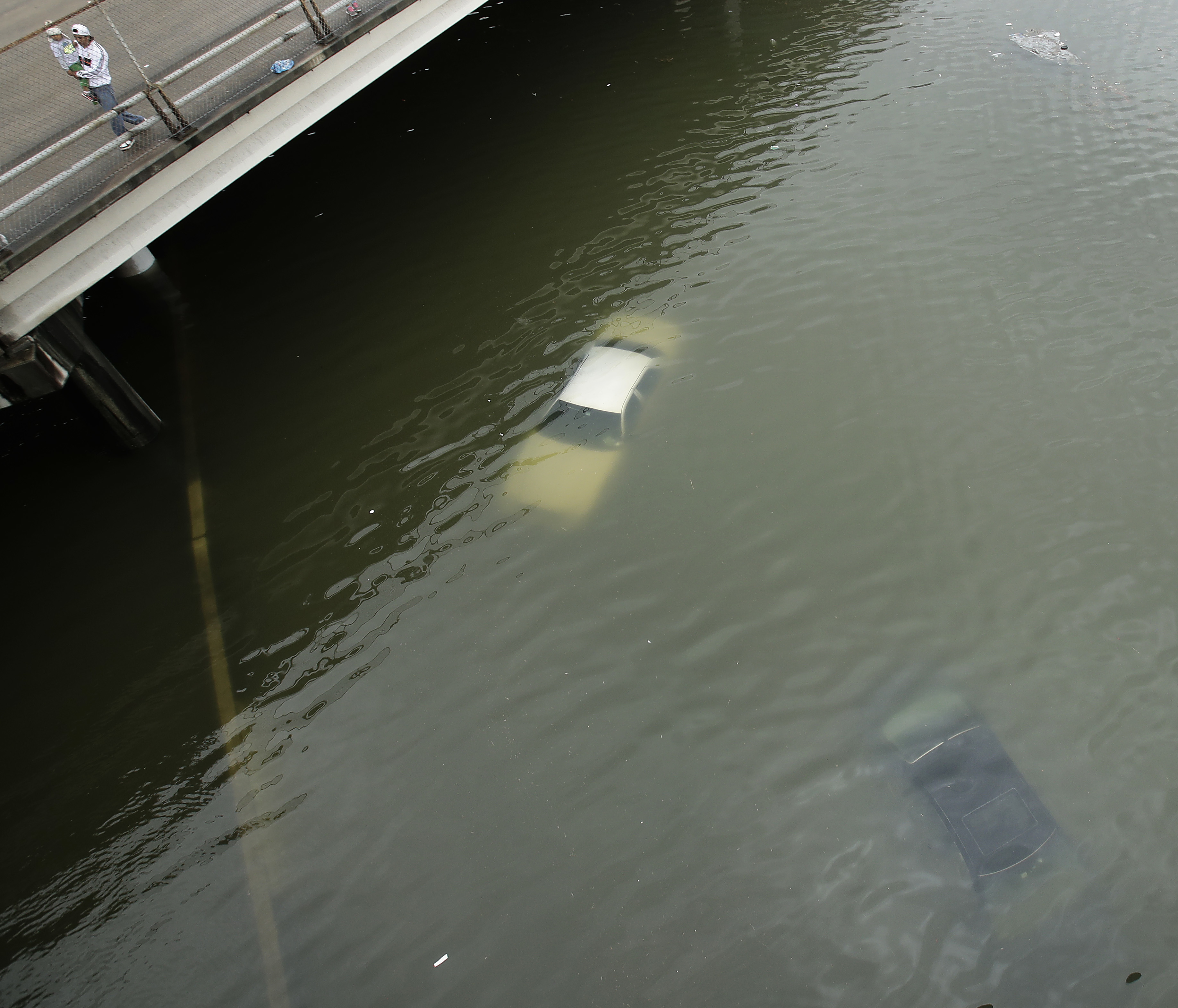 People look at submerged cars on a freeway flooded by Tropical Storm Harvey on Sunday, Aug. 27, 2017, near downtown Houston, Texas.&nbsp;(Charlie Riedel/AP)