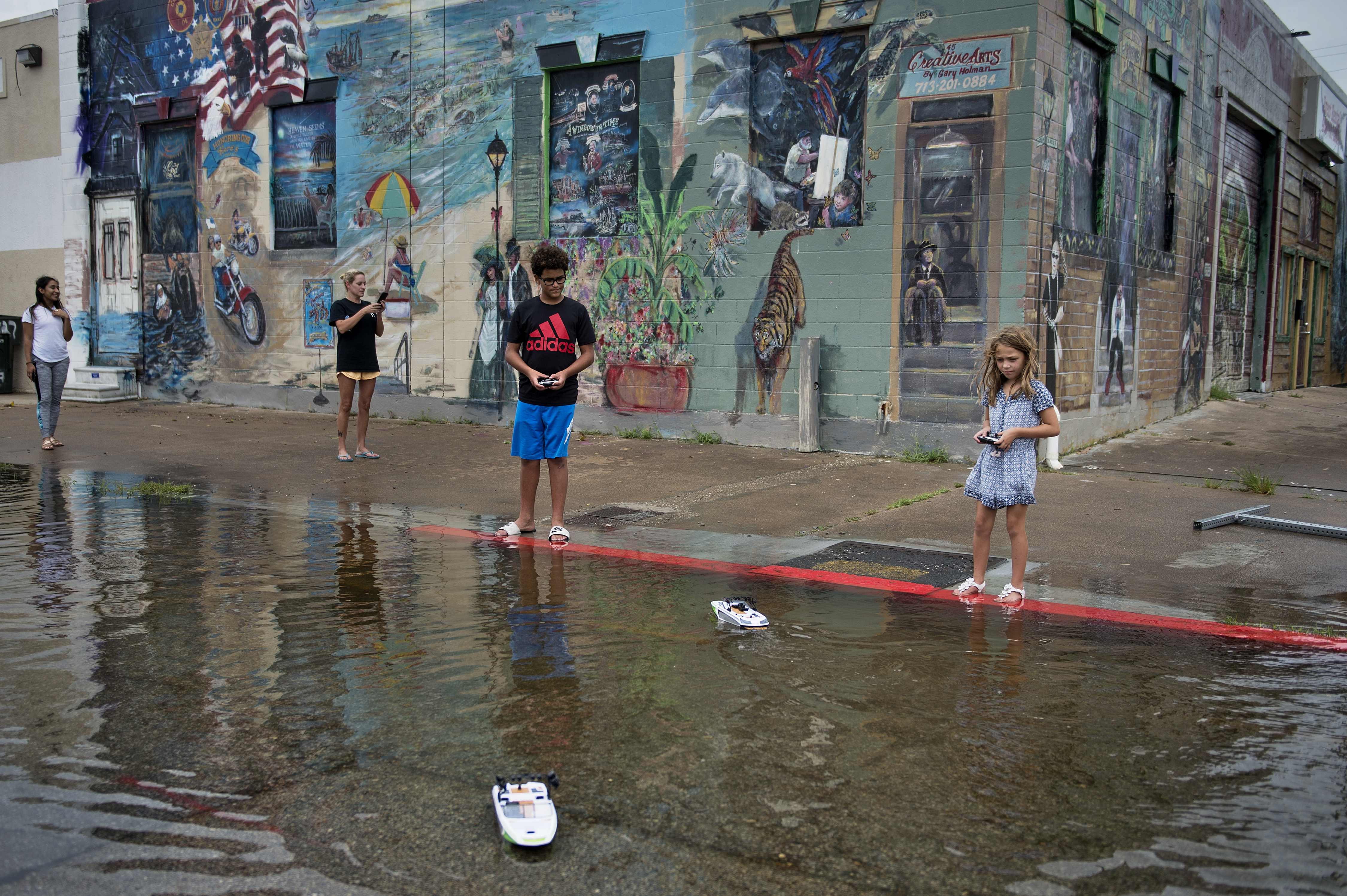 Children play in a flooded road following the passage of Hurricane Harvey on August 26, 2017 in Galveston, Texas.&nbsp;(BRENDAN SMIALOWSKI/AFP/Getty Images)