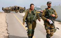 Israeli soldiers block a road in the Israeli-annexed Golan Heights on Feb. 10. Israel struck a dozen Syrian and Iranian targets inside Syria after an Israeli fighter jet crashed under fire from Syrian air defenses.(JALAA MAREY/AFP/Getty Images)