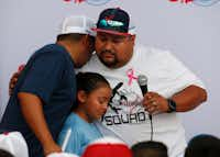 Ray Garcia (left) of El Paso hugs Danny Latin (in white facing left) and his daughter at the end of the candlelight vigil at The Sportspark in El Paso, Texas on Sunday, August 4, 2019.&nbsp;(Vernon Bryant/Staff Photographer)