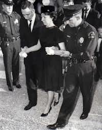 Marie Tippit was escorted by a mourner and a police officer at the funeral of her husband on Nov. 25, 1963. J.D. Tippit was buried at Laurel Land Memorial Park.