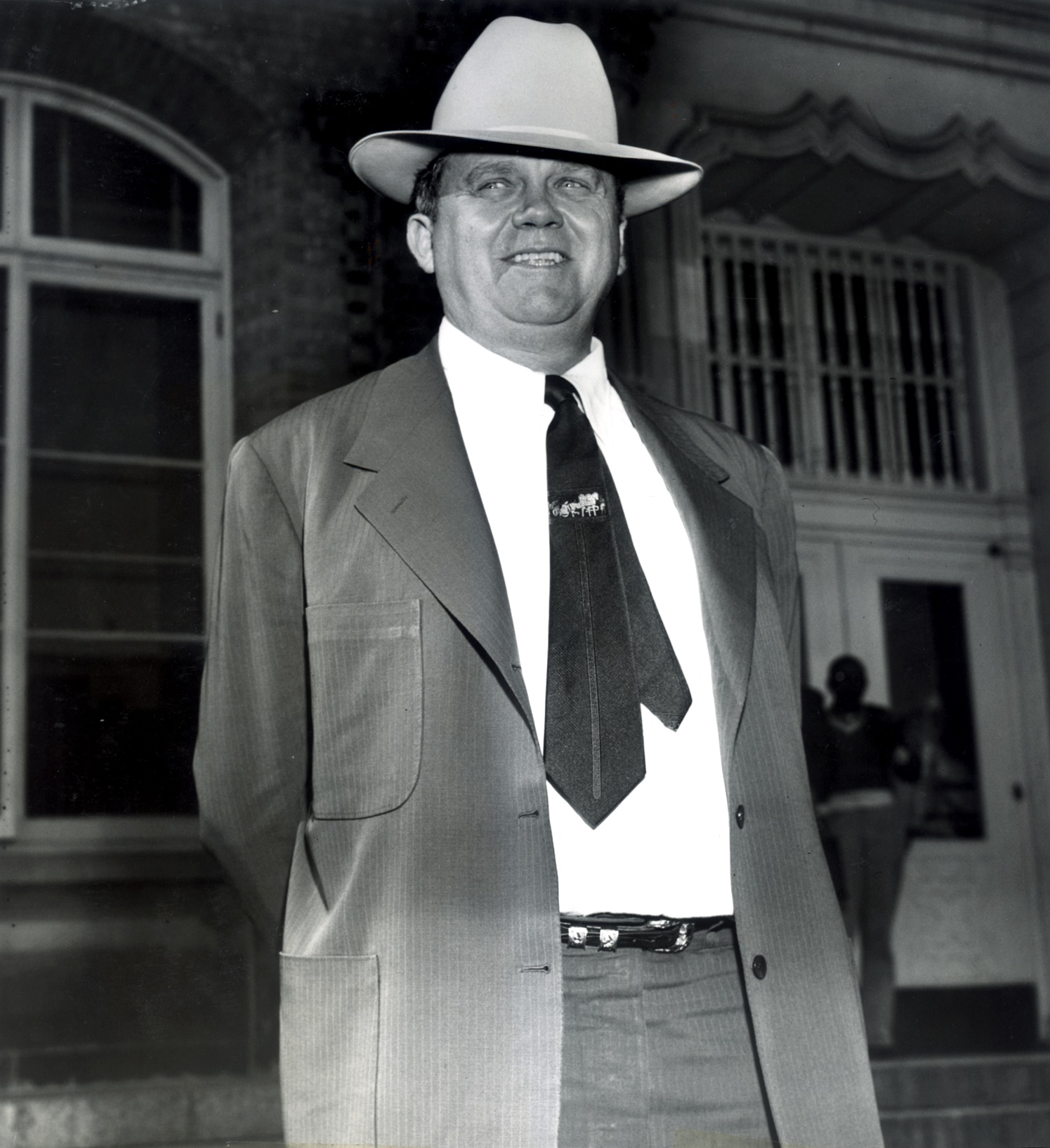 black-and-white photo of man wearing a suit and hat